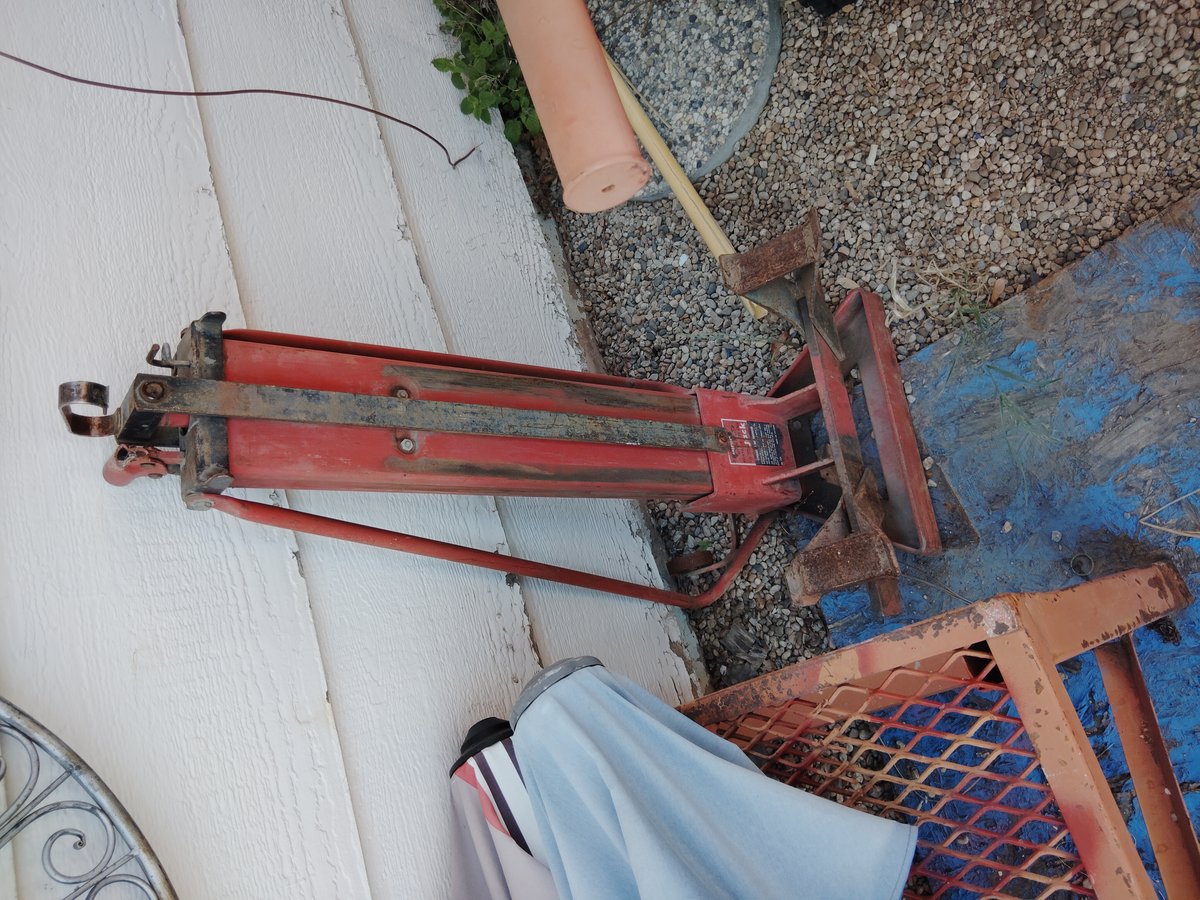 Red metal tool weathered but functional outdoors
