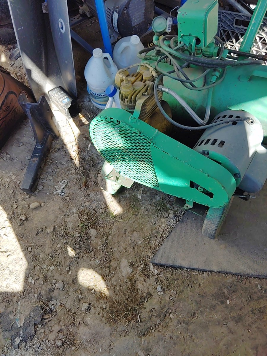 Green industrial machine with visible wear and hoses